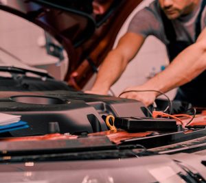 man doing car checkups