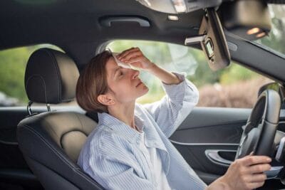 Car air conditioning blowing warm air on a hot day