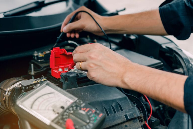Car mechanic is using the car battery meter to measure various v